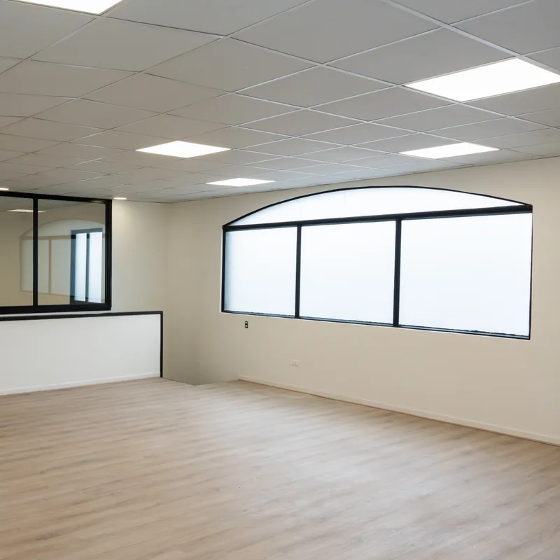 Interior habilitado con piso tipo madera, cielo modular y ventanas curvas