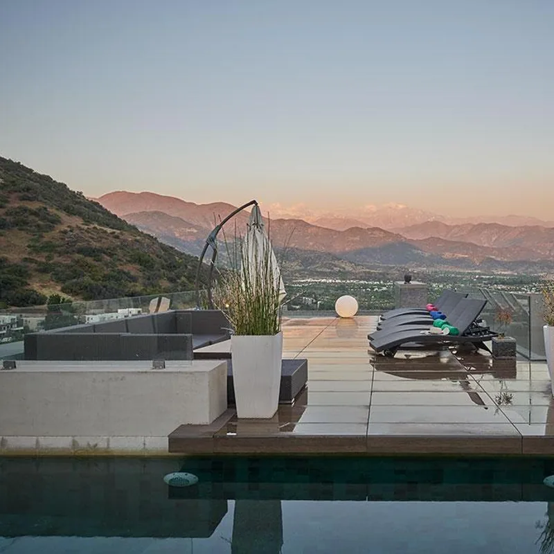Terraza con piscina y vista panoramica hacia el valle al atardecer