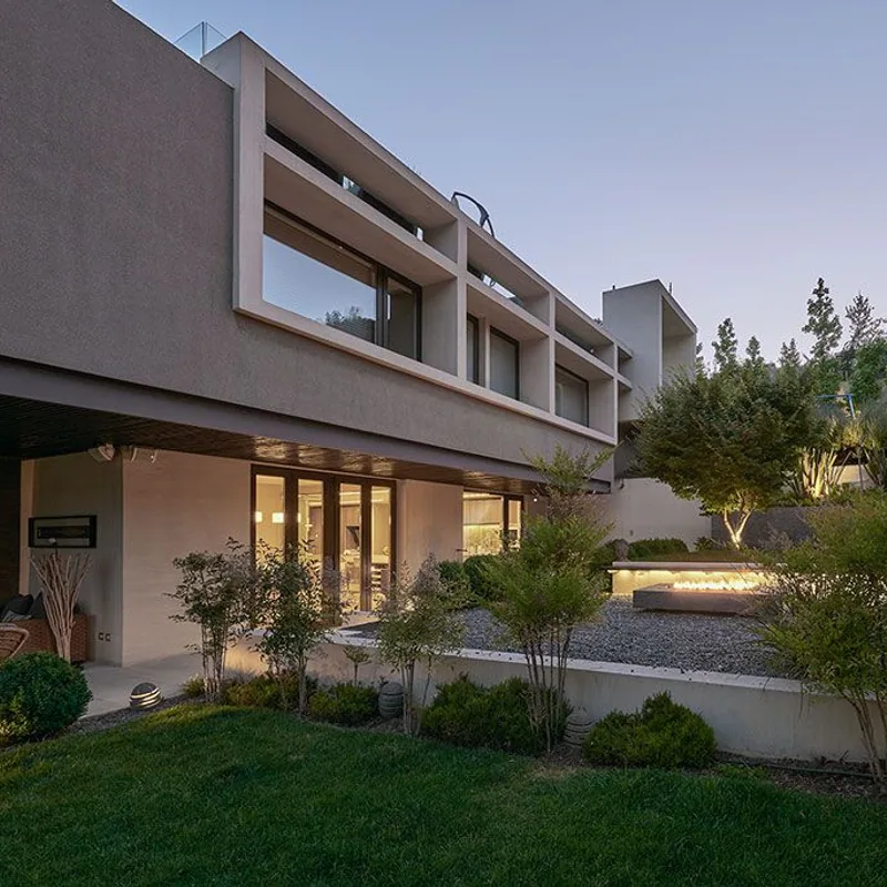 Espacio exterior residencial con terminaciones de muro, vegetacion e iluminacion