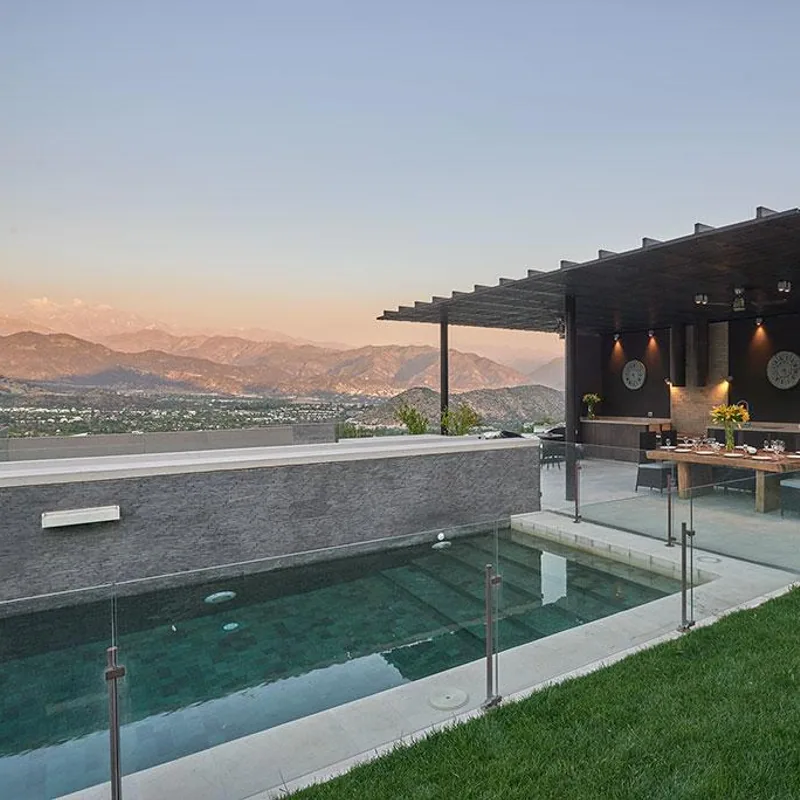 Terraza residencial con piscina, quincho y vista hacia la ciudad