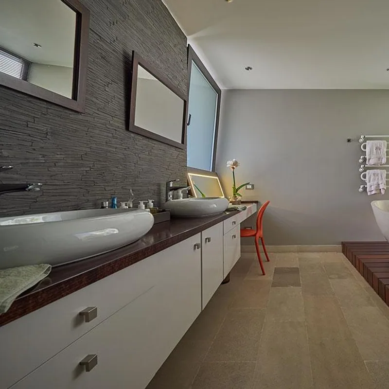 Bano residencial con cubierta de madera, doble lavamanos y revestimiento oscuro