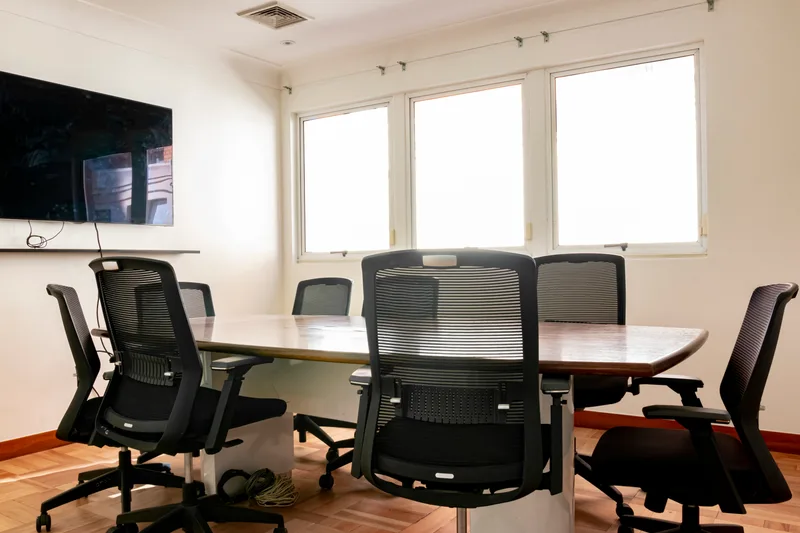 Sala de reunion corporativa equipada con mesa y sillas