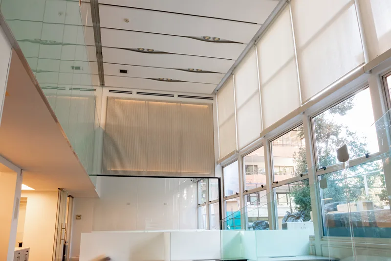 Acceso interior con doble altura, vidrio y circulaciones corporativas